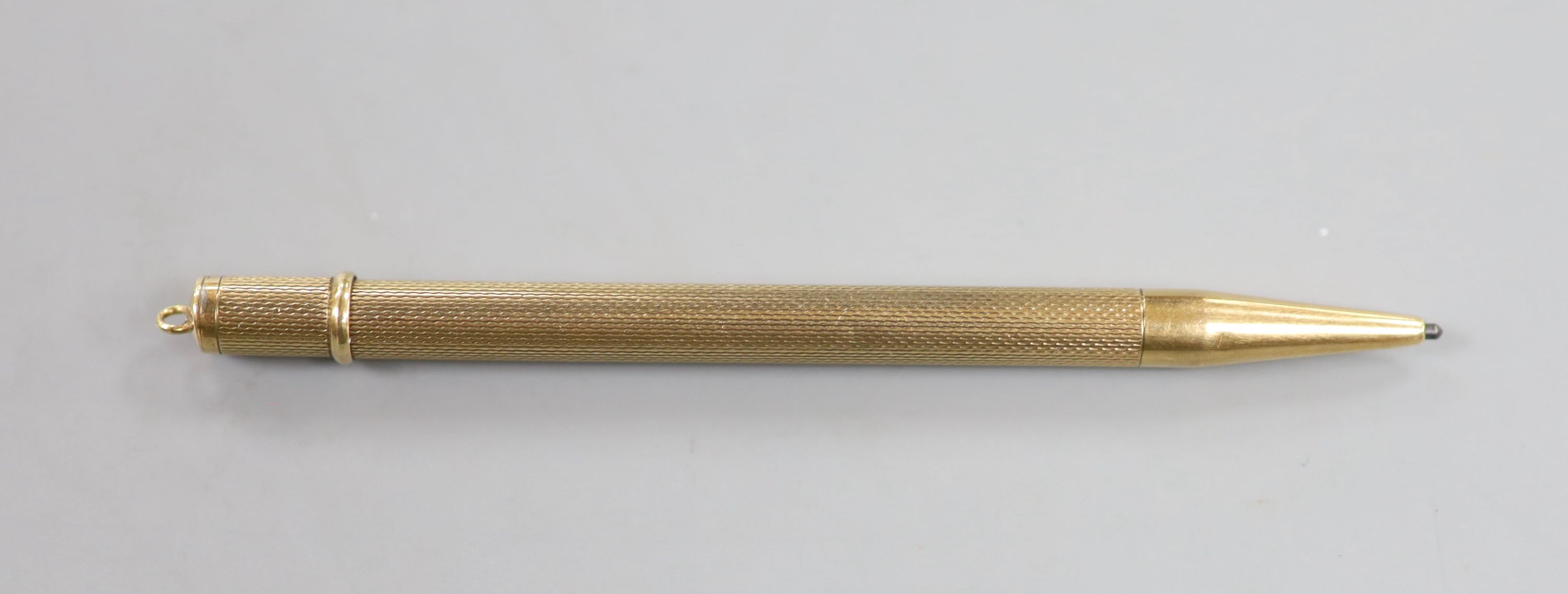 An engine turned 9ct gold cased pencil, 86mm, gross weight 10.5 grams.